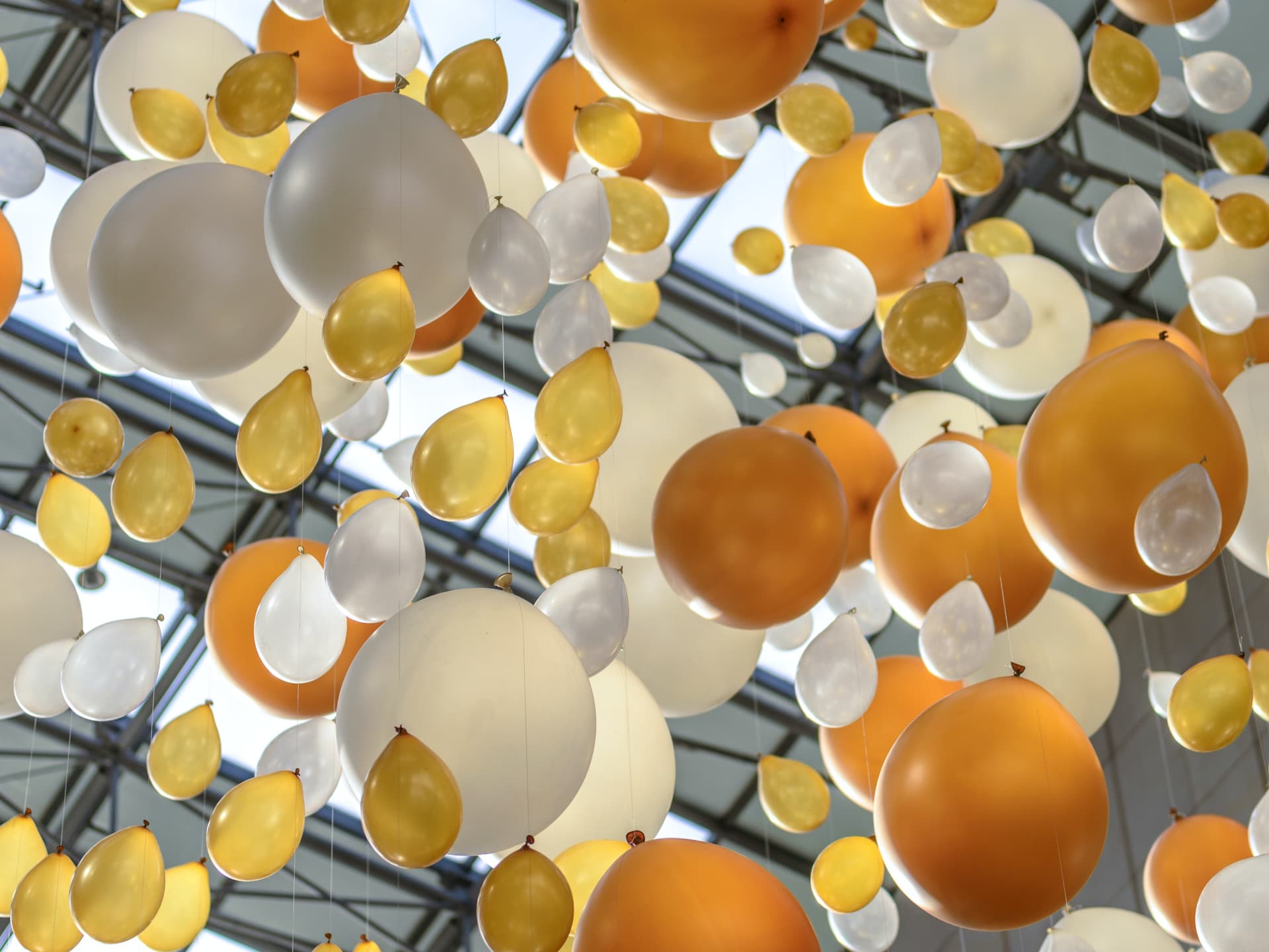 White and gold balloons tied to a string